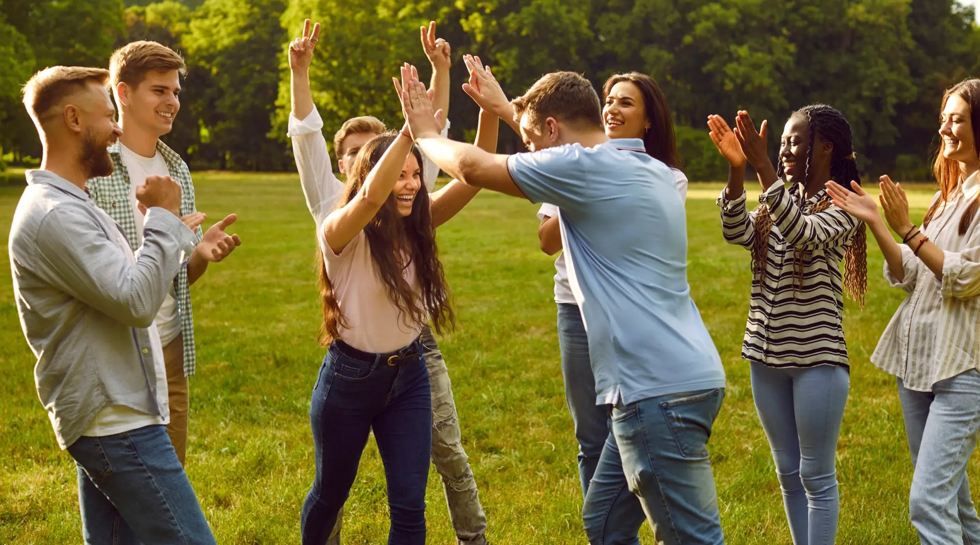 Groupe de personnes joyeuses dans un parc extérieur durant un événement team building