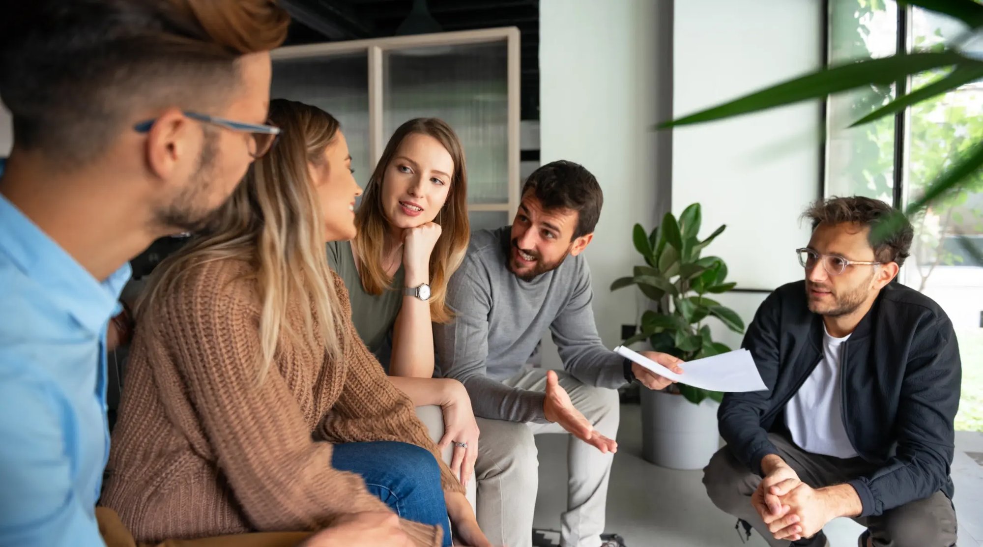 Groupe de jeunes professionnels discutant ensemble